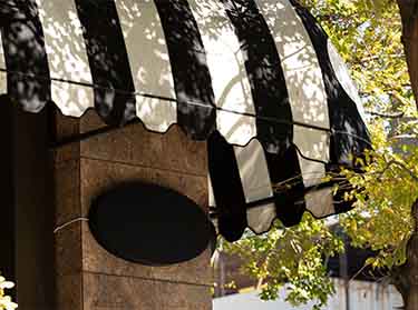 Professional awning cleaning in NYC, removing dirt, stains, and debris to enhance the appearance and longevity of commercial building exteriors.